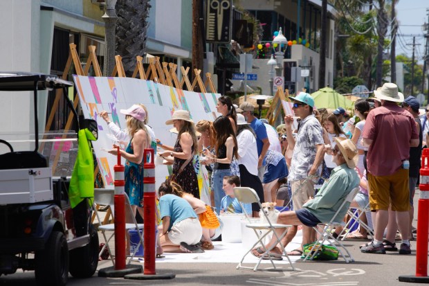 At the 45th Annual Ocean Beach Street Fair & Chili Cook-Off on Saturday, June 28, 2025, in San Diego, several painters take part in the large "community mural" project. (Nelvin C. Cepeda / The San Diego Union-Tribune)