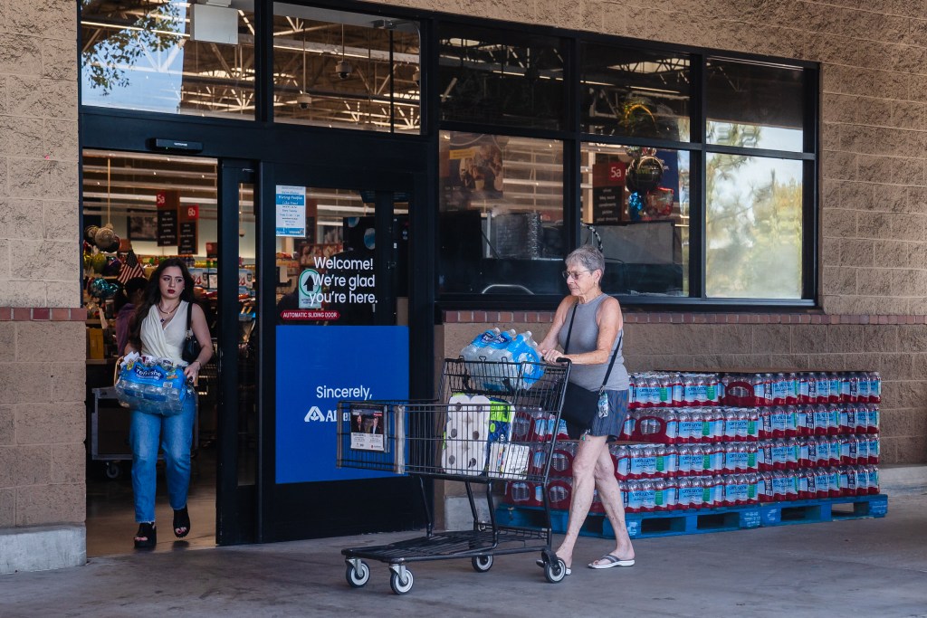 Women walk out of Albertson's grocery store with bottles of water in Alpine, Calif on Aug. 18, 2023.