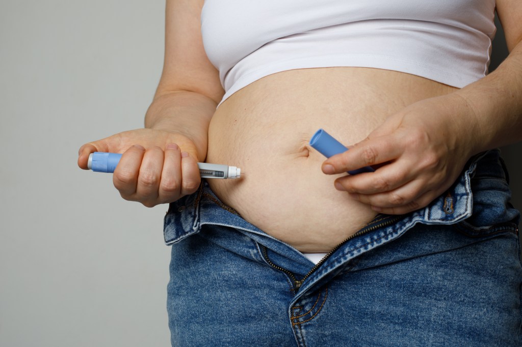 Woman injecting semaglutide.