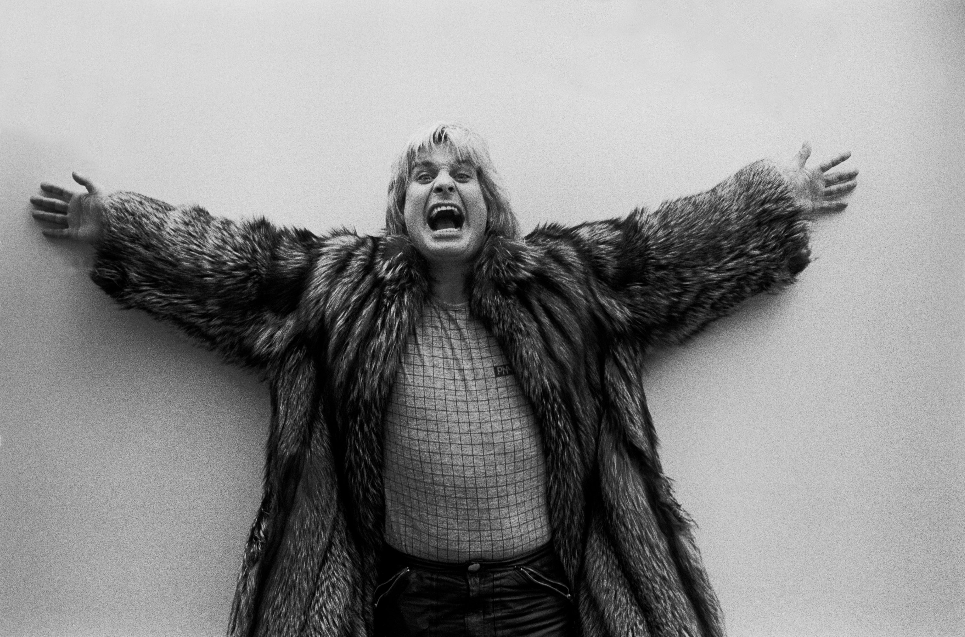 Black and white photo of Ozzy Osbourne in a fur coat.