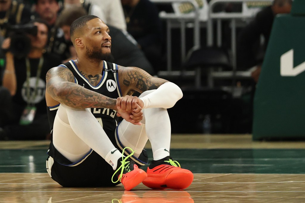 Milwaukee Bucks player sitting on the court.