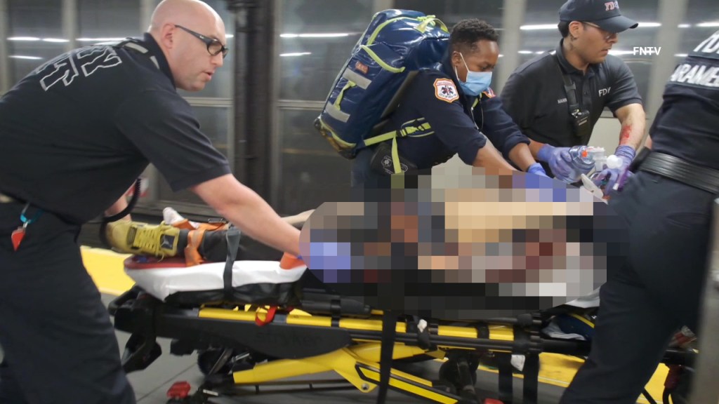 First responders transporting an injured person on a stretcher.