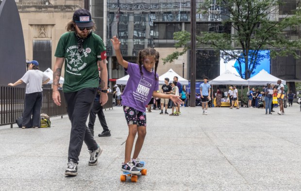 Matt Keeth, left, teaches Daisha Vasquez, 9, how to ride...