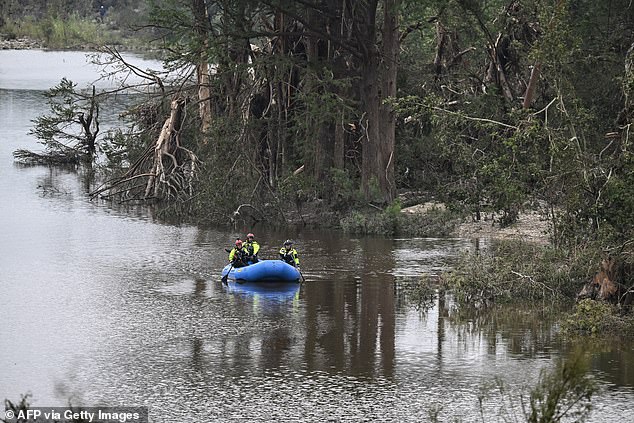 Members of a rescue team look for missing people on the Guadalupe River on Sunday