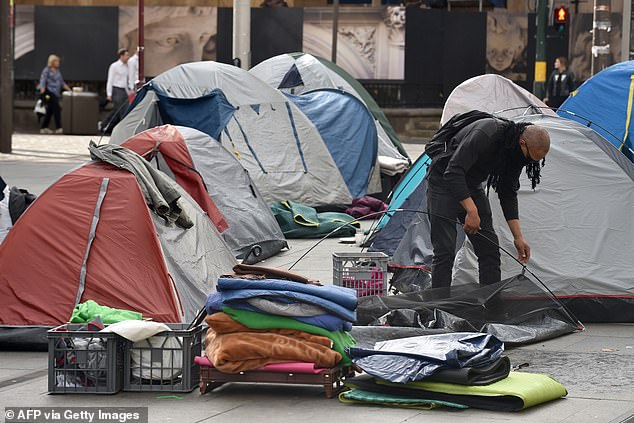 A homeless man packs up his tent in the central business district of Sydney