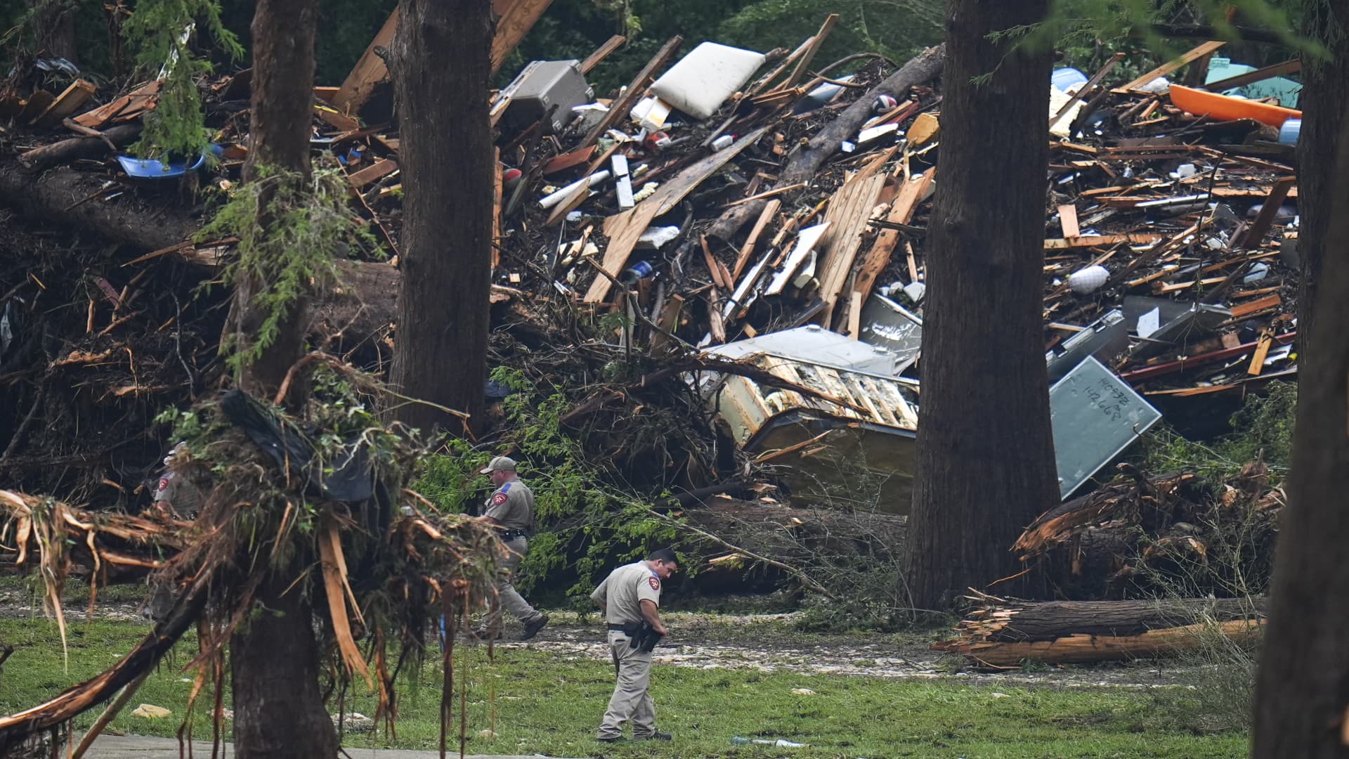 Officials comb through the banks of the Guadalupe River after a flash flood swept through the area on Saturday, July 5, 2025, in Hunt, Texas.