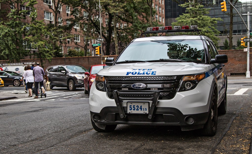 NYPD police car parked on a city street.