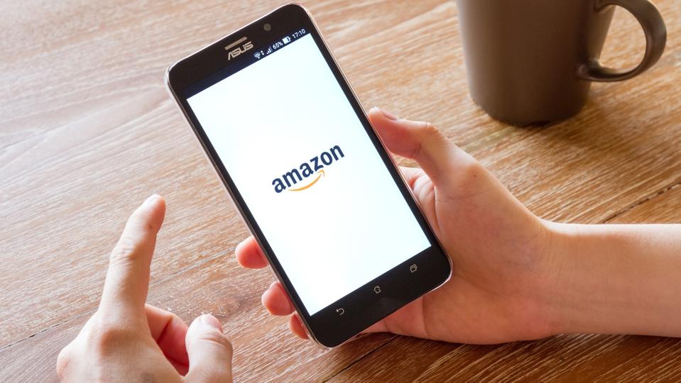 man hand holding screen shot of Amazon application