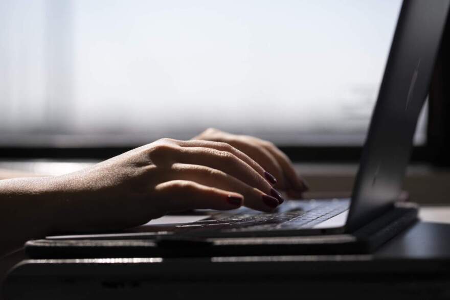 A woman typing on a laptop on a train in New Jersey. (Jenny Kane/AP)