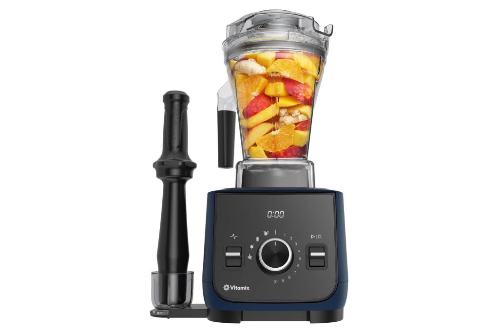 A Vitamix Blender with fruits inside it.