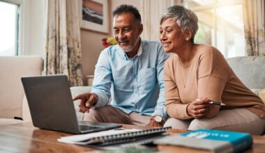 Mature couple on sofa using a laptop for planning finances.