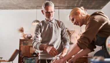 Low angle view of the cheerful blonde woman packing ceramic dishes at the craft paper and boxes and smiling.