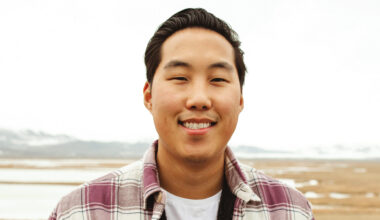 Preston Seo smiling outside with open land behind him