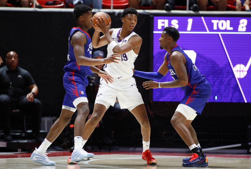 Three basketball players vying for the ball during an NBA Summer League game.