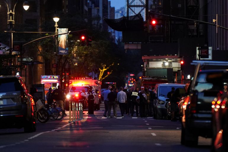Federal agents, center, and NYPD officers close off East 50th Street between Madison and Park Avenues