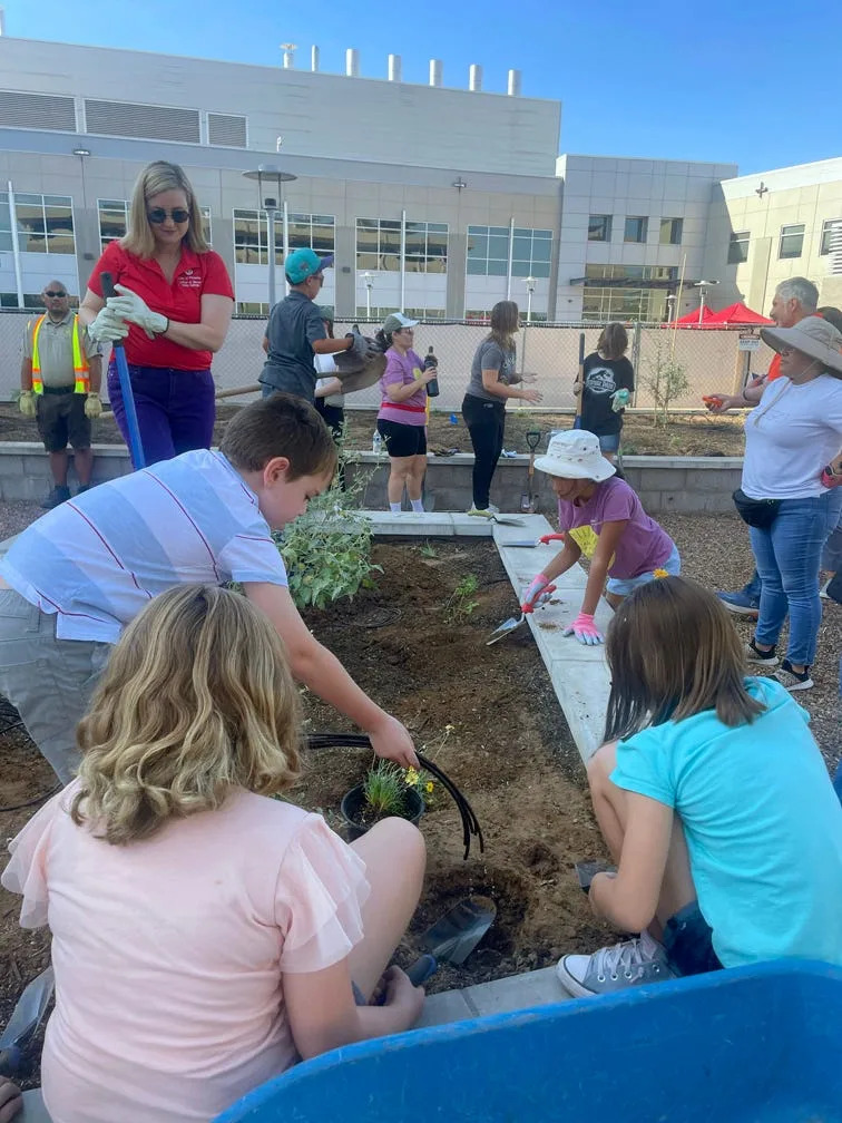 Phoenix Mayor Kate Gallego helps volunteers plant a pollinator garden outside the Phoenix Crime Lab in September 2024.