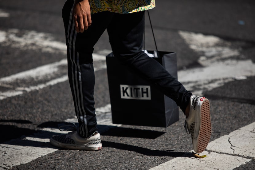 A pedestrian carries a Kith shopping bag while crossing a street in New York, U.S., on...