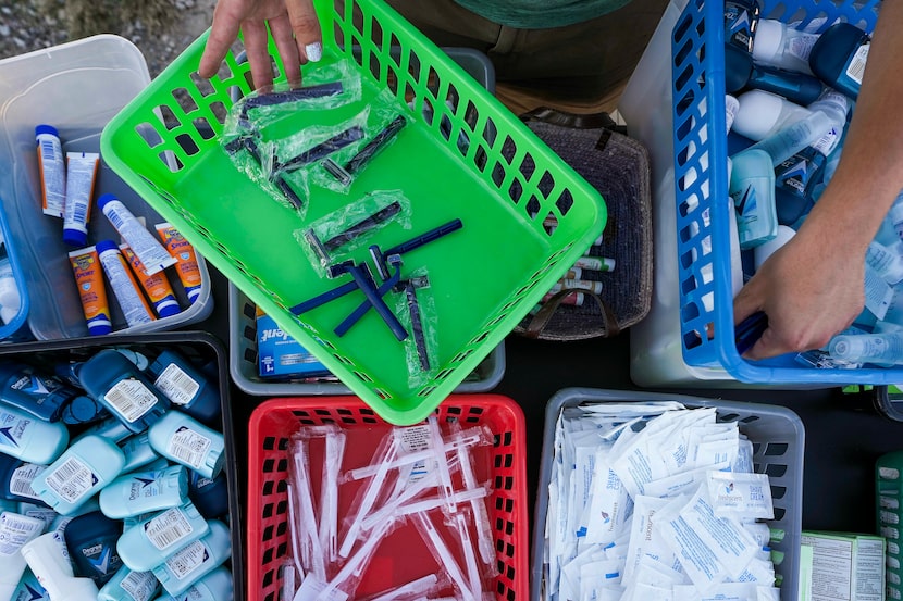 Volunteers with the aid group Dallas Sandwich Sundays set up to distribute toiletries, food,...