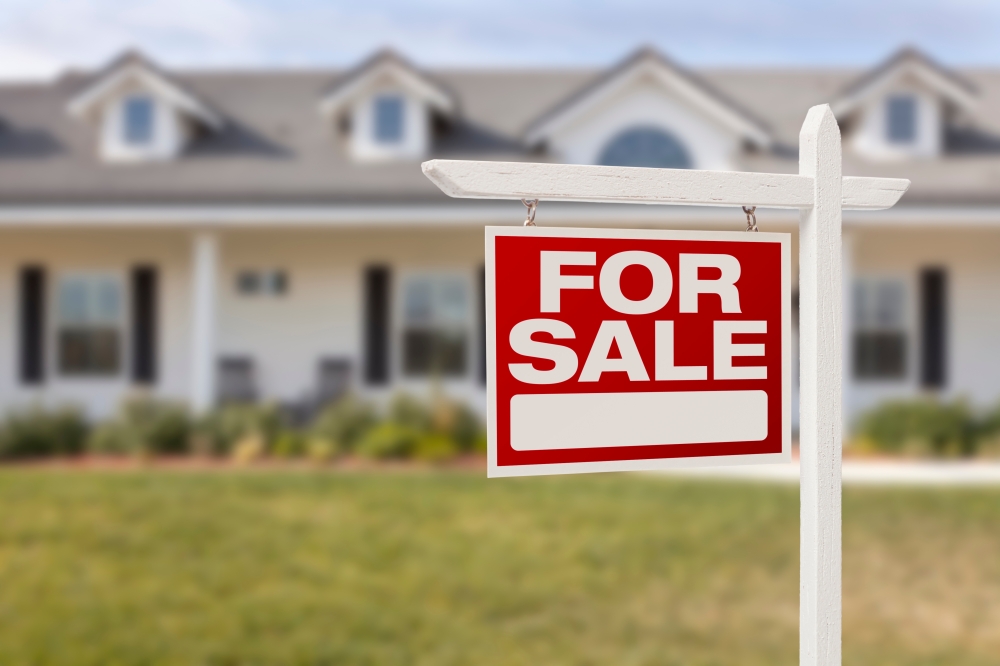 a for sale sign in front of a house