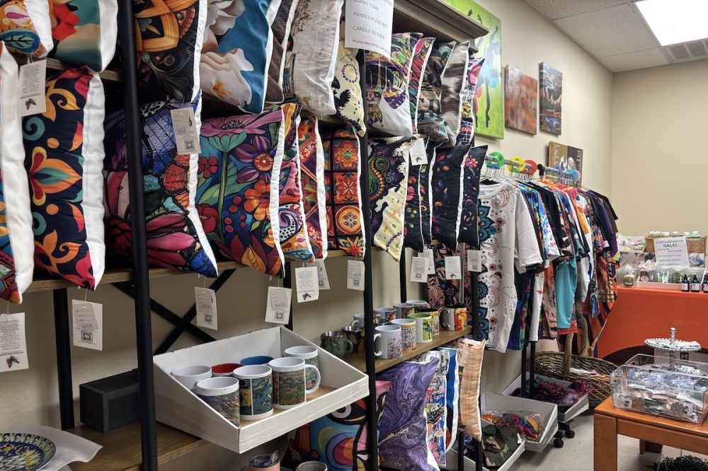 A shelf full of colorful pillows surrounded by an assortment of jewelry and other goods.