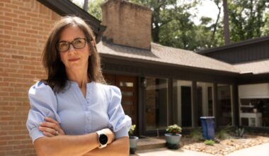 Jennifer Coulter stands in front of her Kingwood home, which was renovated after flooding from Hurricane Harvey in 2017. She said she's seen her insurance rates spike in recent years. (Raphael Fernandez/Community Impact)