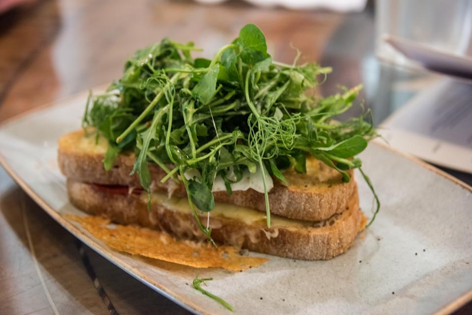 Irish toasted sourdough bread with a avocado, feta cheese, pomegranate seeds, chilli flakes, rocket and poached eggs