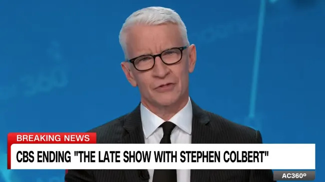 News anchor reporting CBS ending "The Late Show with Stephen Colbert" on a broadcast with a blue studio background