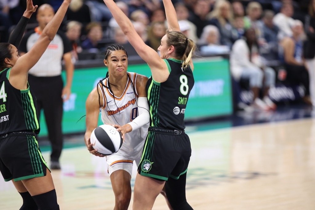 Phoenix Mercury forward Satou Sabally leans to her right holding the ball while Minnesota Lynx forward <a rel=