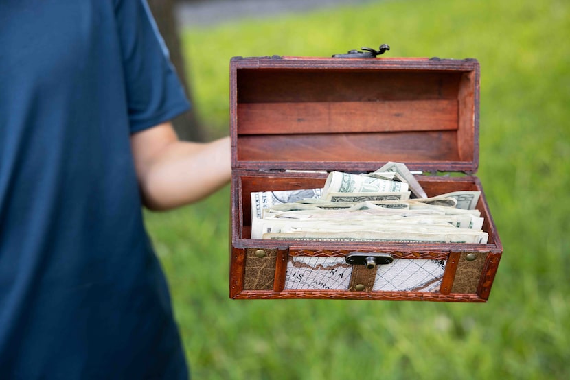 Caden Wallace, 12, holds some of the money raised for Camp Mystic through his lemonade stand...