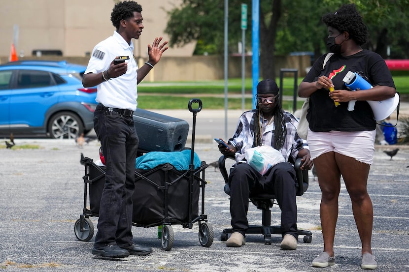 A security guard asks volunteers with the aid group Dallas Sandwich Sundays to remain on the...