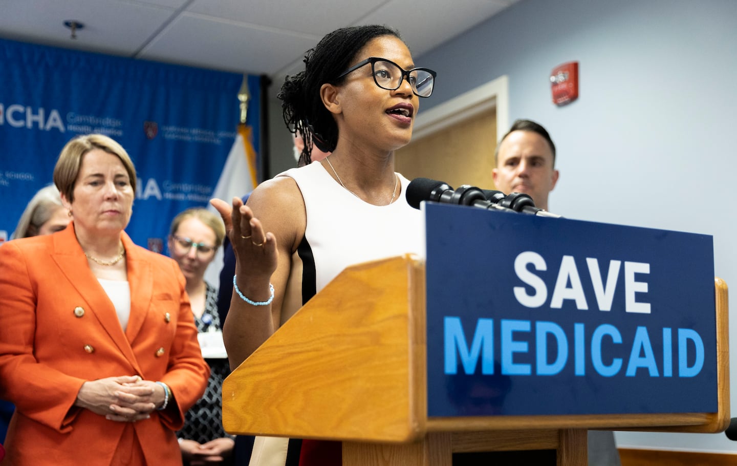 State senator Lydia Edwards shared her thoughts about what would happen if the Medicaid budget was cut during a visit to the Cambridge Health Alliance Revere Care Center in May. State officials, including Governor Maura Healey (left), were at the event.