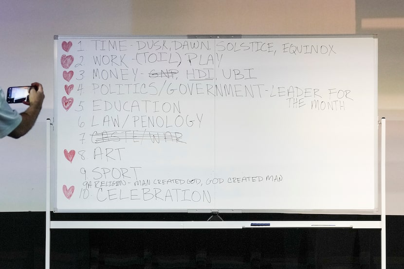 People take photos of a white board containing themes from his talk after director Francis...