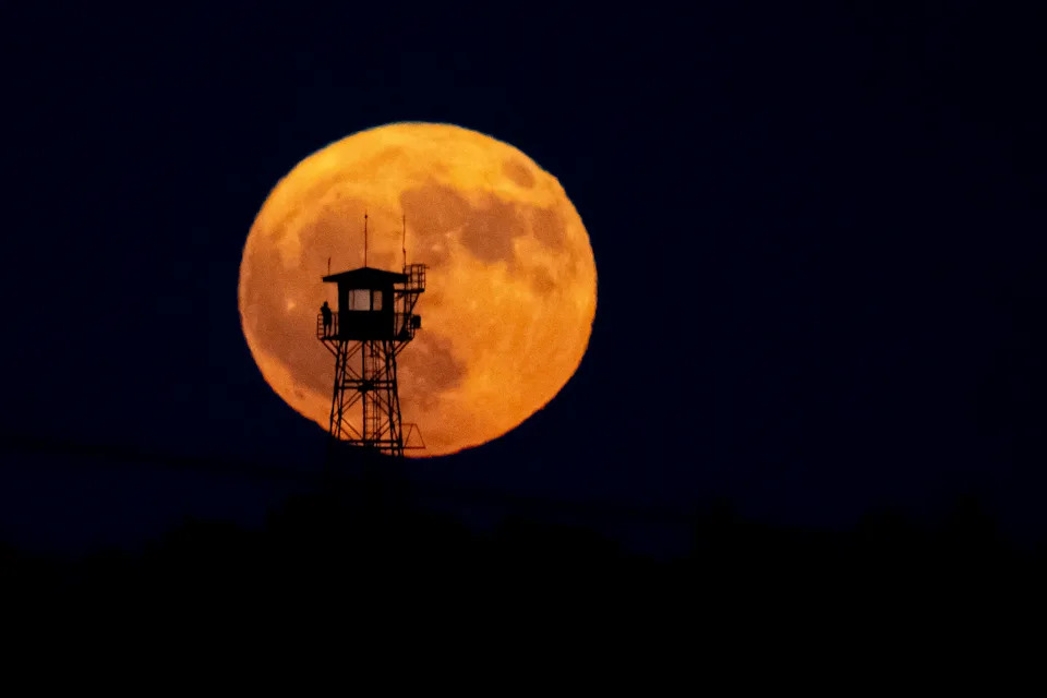 A lookout watches the moonrise from a wildfire surveillance tower in Madrid. 