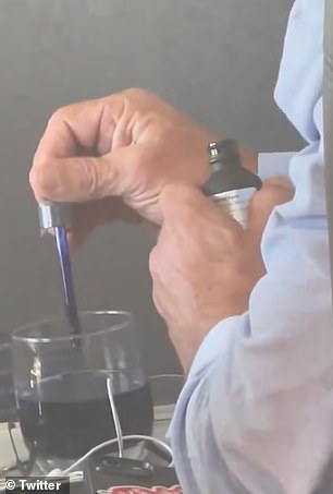 He is here seen squeezing a bright blue dye in what looks like water