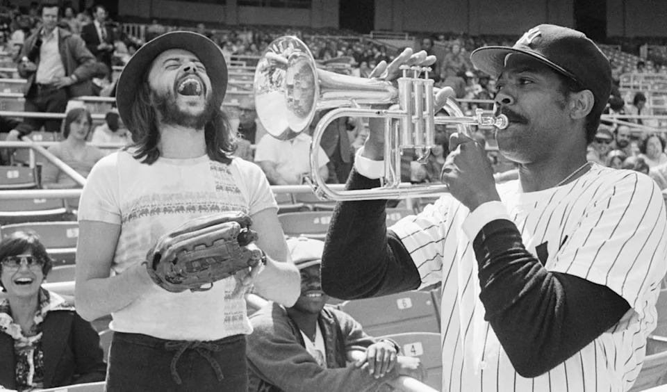 New York Yankees Pitcher Dock Ellis, right, has a little fun with a Chuck Mangione's horn before a game with the Toronto Blue Jays at Yankee Stadium on April 19, 1977, in New York. (AP)