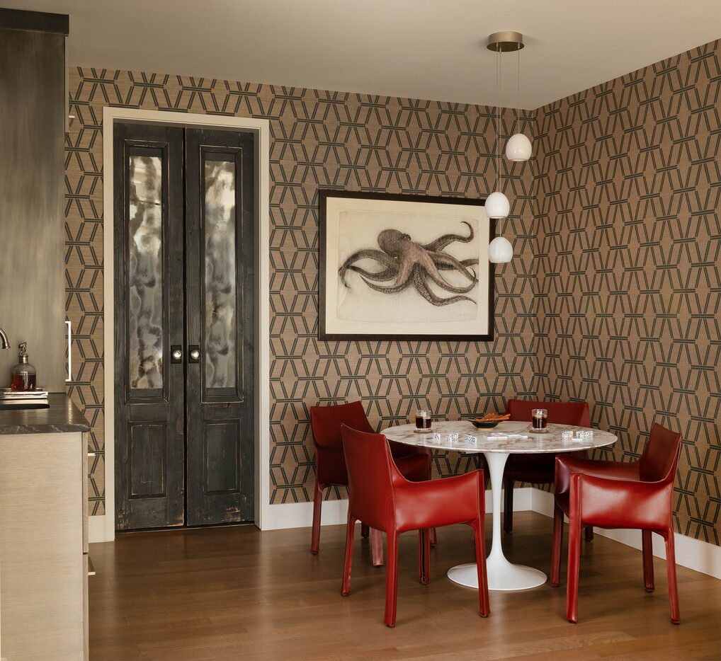 In the den, a Saarinen dining table and Mario Bellini Cab armchairs in red leather from...
