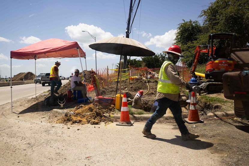 Workers as construction continues on the Lake June Road bridge in Dallas on Friday, July 18,...