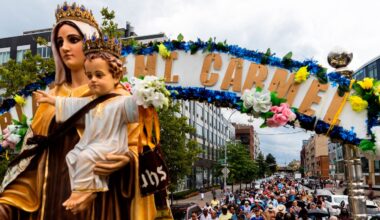 Parishioners walk behind a float carrying Our Lady of Mount Carmel, Saturday, July 16, 2022. (AP Photo/Julia Nikhinson)