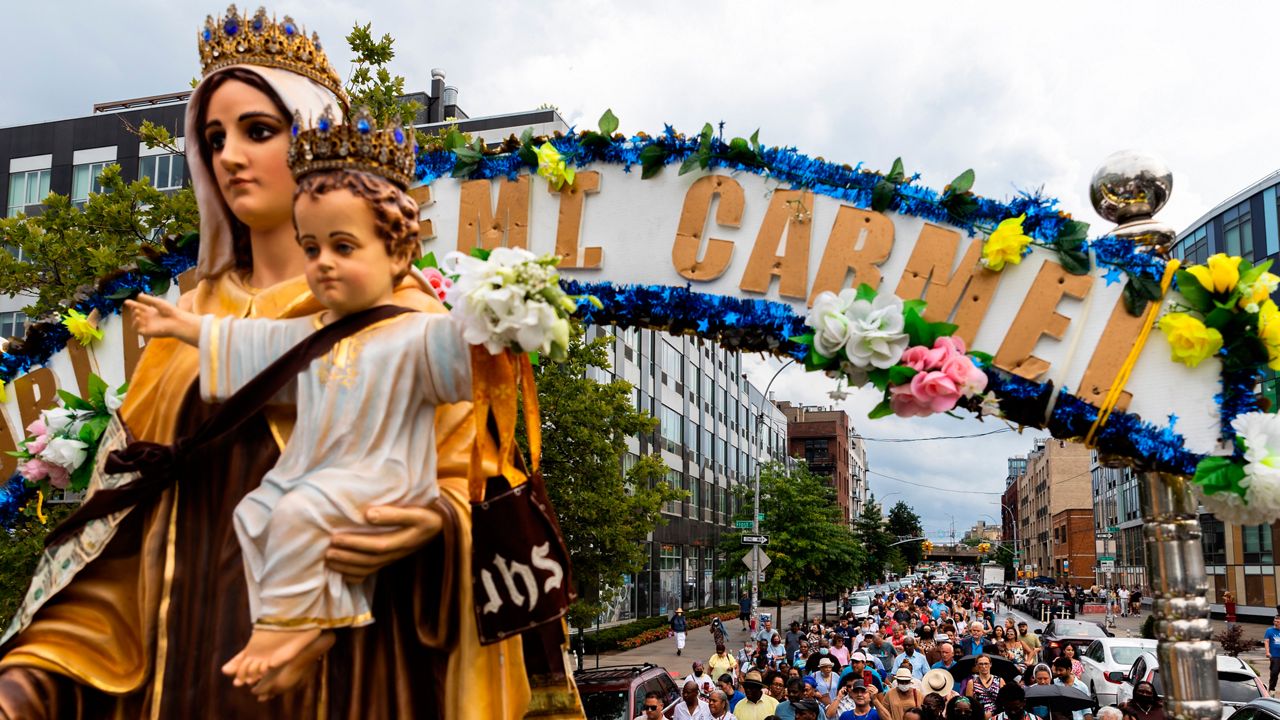 Parishioners walk behind a float carrying Our Lady of Mount Carmel, Saturday, July 16, 2022. (AP Photo/Julia Nikhinson)