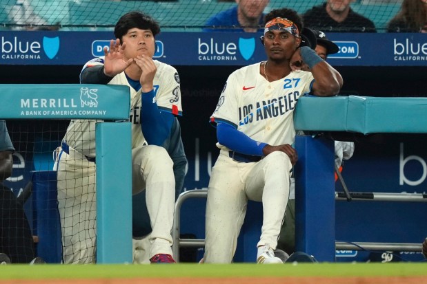 Dodgers' Shohei Ohtani, left, and Esteury Ruiz watch from the dugout during the ninth inning of a baseball game against the Milwaukee Brewers, Saturday, July 19, 2025, in Los Angeles. (AP Photo/Mark J. Terrill)