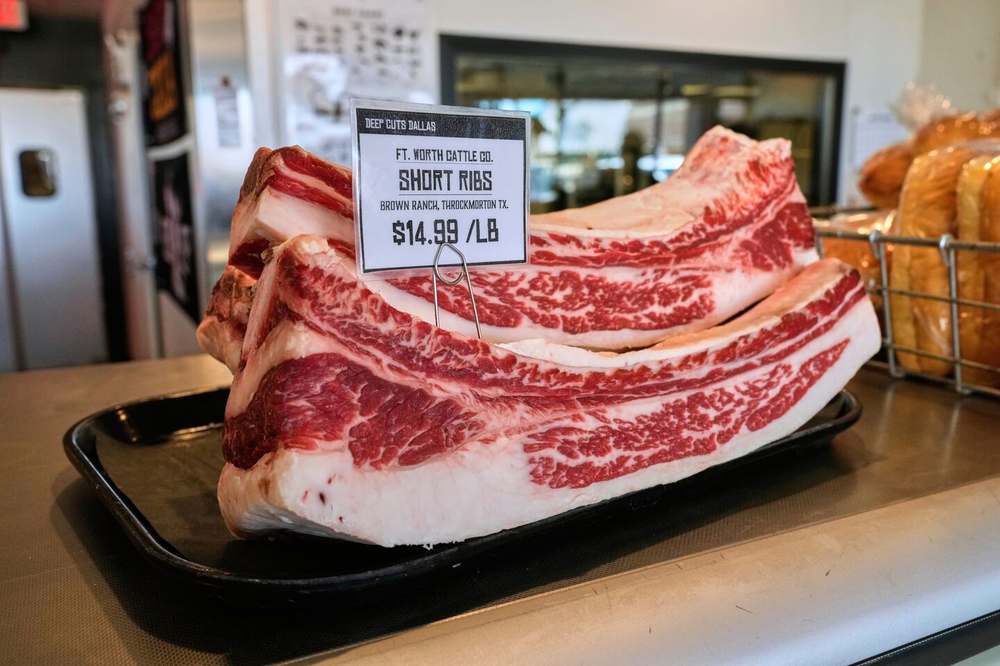 Several pounds of short ribs show the price per pound at Deep Cuts Dallas Butcher Shop.