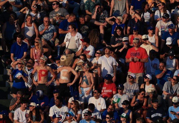 A trio of Cubs center fielder Pete Crow-Armstrong fans wear body pain spelling out his initials in the second inning against the Guardians at Wrigley Field on July 3, 2025, in Chicago. (John J. Kim/Chicago Tribune)