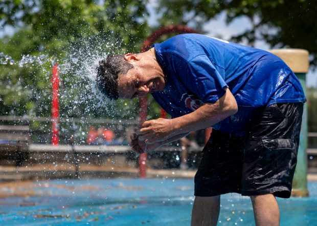Javier Gonzalez cools off in a fountain before umpiring baseball...