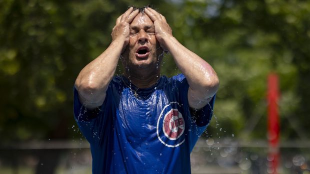 Javier Gonzalez cools off in a fountain before umpiring baseball...