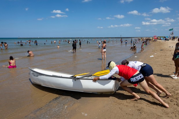 Lifeguards push a boat into Lake Michigan on on June...