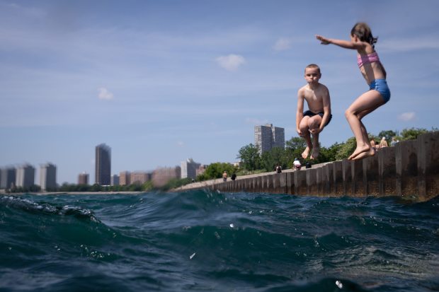 Lewis Moore, 9, left, jumps off the pier at Montrose...