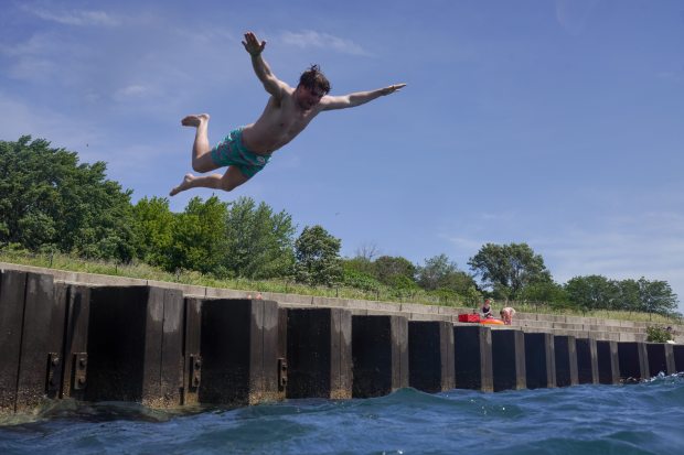 Alex Zaliagiris jumps off the pier at Montrose Beach on...