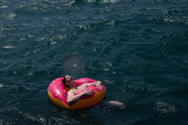 Joe Kraft lays in a donut float after jumping off...