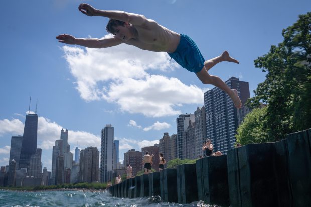 Bryce Burns leaps into the water at the pier near...
