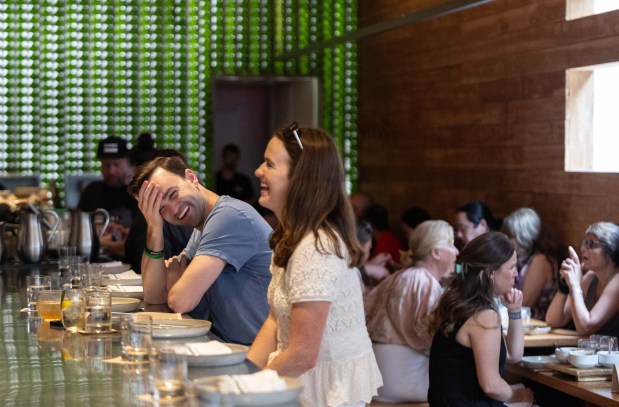 Patrick Boos, of Glenview, laughs with his cousin Mary Kerrigan as they dine at Avec, July 25, 2025, in Chicago's West Loop. (Dominic Di Palermo/Chicago Tribune)